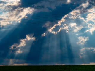 Sonne bricht durch dunklen Wolkenhimmel