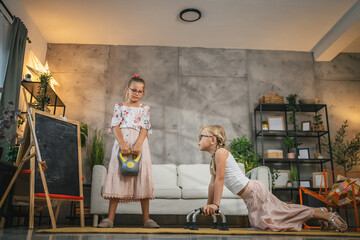 Young girl child play with push up bars on the floor and kettle bell