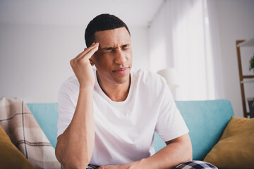 Photo of depressed sad guy nightwear pajama having headache sitting couch indoors room home house