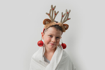 Young boy with reindeer antlers and Christmas baubles