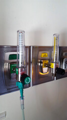Yellow and clear wall-mounted oxygen meters at hospital