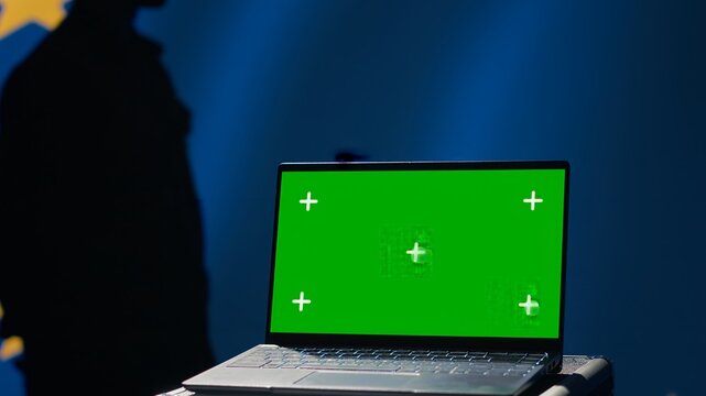 European Union agency using green screen laptop to protect against mass propaganda affecting elections. EU security service engaging in psychological operations using mockup device, close up, camera A - Powered by Adobe