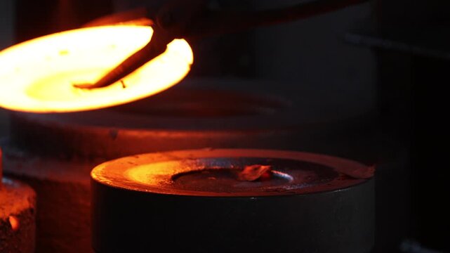Forging industry, hammer forges metal piece shaping drop hammer to give it a tool shape. Open die forging hit by hammer on a tool to form an automatic machine component, parts tools, forge factory.