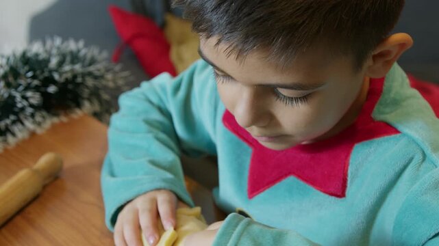 Cute child little elf making christmas ginger bread cookies. High quality 4k footage