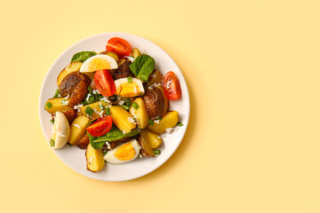 Plate of tasty potato salad with eggs and tomatoes on beige background, top view