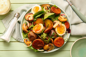 Plate of tasty potato salad with eggs and mushrooms on wooden table, top view