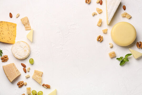 Frame made of different types of tasty cheese and nuts on light background