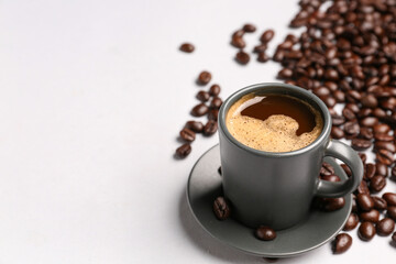 Cup of coffee and beans on grey background