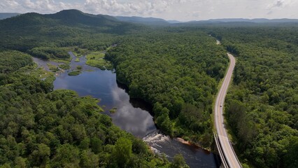 Fototapeta premium Beautiful green mountain range with gentle creeks in valley under blue sky with clouds in summer Adirondack Mountains New York State West Canada Creek Historic Confluence