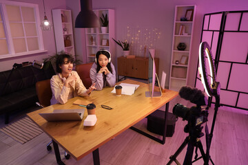 Young women recording podcast in studio at night
