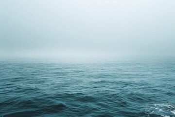 Fototapeta premium A boat sailing on calm ocean waters with blue sky and sea spray