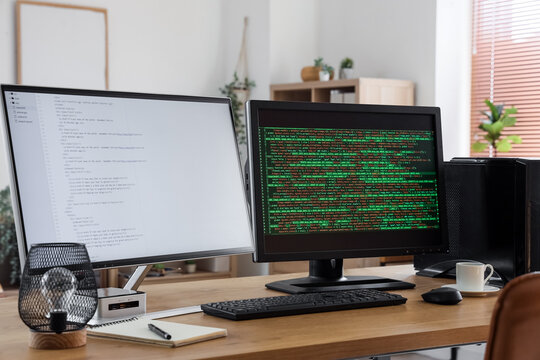 Modern workplace of programmer with double monitor in stylish office