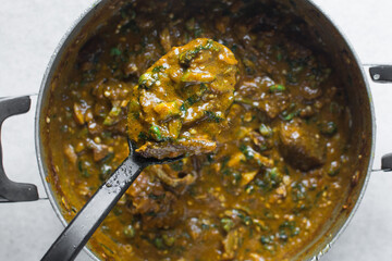 Overhead view of nigerian ogbono soup in a pot, top view of ogbono draw soup with assorted meats in a soup pot, flatlay of nigerian ogbono and okra soup