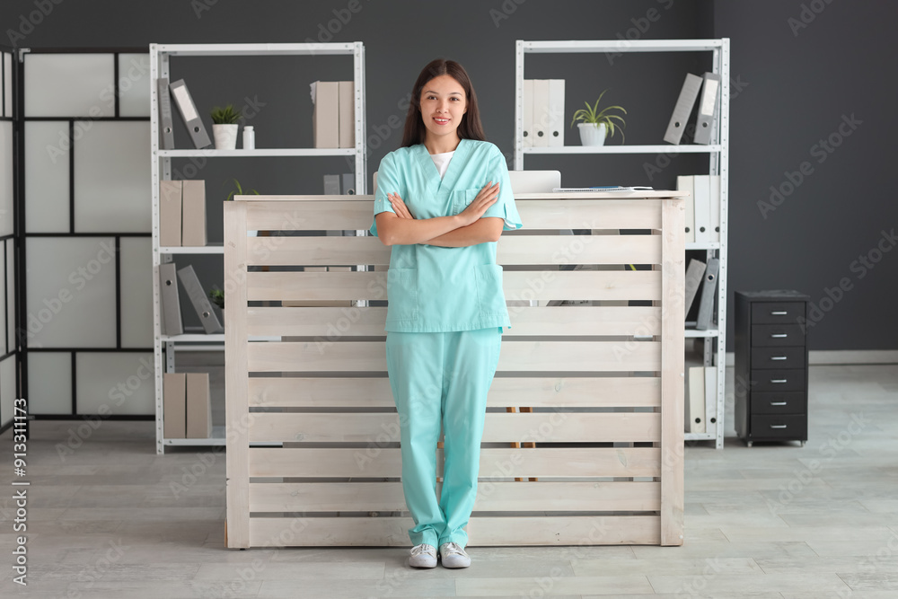 Poster young female medical receptionist near reception desk in hospital