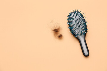 Brush and clump of hair on beige background. Hair loss concept