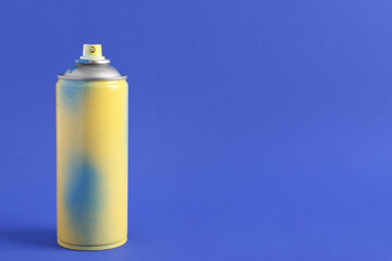 Spray paint can on blue background