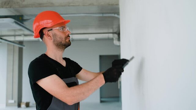 The builder putty a white wall in the room, renovation of apartment