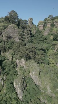Vertical drone video. Rock formations, forested mountains and large formations. Hiking through the green forest. Hiking concept. Amatlan, Mexico