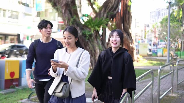 Taiwanese man and woman in their 20s and a South Asian woman walking together and chatting amicably on a street near a university in Da&rsquo;an District, Taipei City, Taiwan.&nbsp;