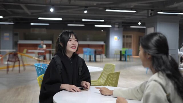 A Taiwanese woman and a South Asian woman in their 20s chatting amicably in a university cafeteria in Da&rsquo;an District, Taipei City, Taiwan.&nbsp;