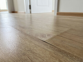 The laminate flooring in the room was damaged due to water penetrating the wood for too long.