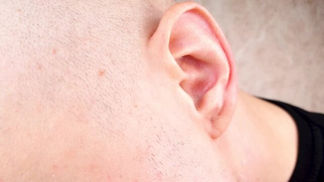 A man's ear. A man's left ear. Concept of hearing, human ear, study,hearing research.