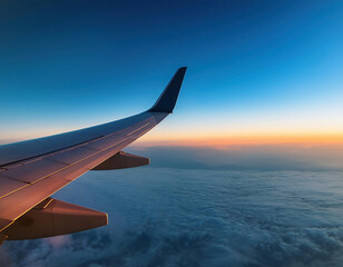 Obraz premium wing of airplane flying in cloudless evening sunset sky.