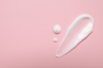 Face cream on pink background, top view. Space for text