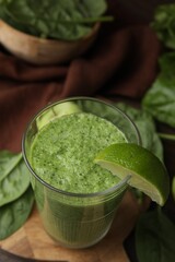 Tasty green smoothie in glass with lime on table, above view