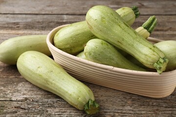 Raw green zucchinis on wooden table, closeup