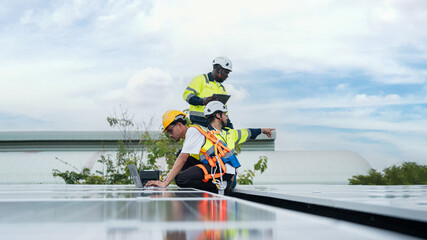 Technicians in safety gear examine rooftop solar panels during maintenance. The image represents...