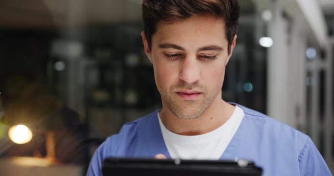 Night, healthcare and man doctor with tablet for emergency, consulting or checking surgery schedule in lobby. Hospital, app and surgeon intern at clinic with digital chat, scroll or Telehealth help