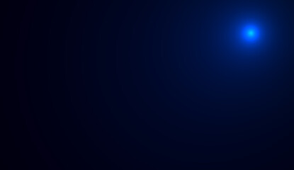 Small particles of dust illuminated by a blue beam of light on a black  background. a small blue light with a dark background.