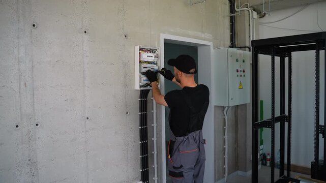 Electrician installing electrical panel in office or house