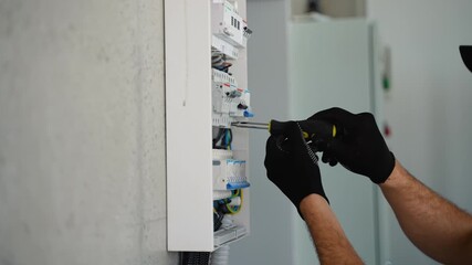 Technical electrician fixing the cable into the terminal of a circuit breaker of a electrical panel