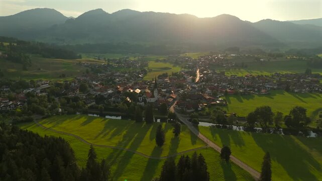 Aerial view of Fischen im Allgau near Oberstdorf at sunset in sunny summer weather in Bavaria, Germany Landkreis Oberallgau. Fischen im Allgaeu Luftaufnahme. Pfarrkirche St. Verena. Frauenkapelle. 