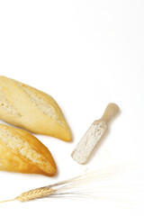Loaves of bread with flour and ears of wheat isolated on white background and copy space