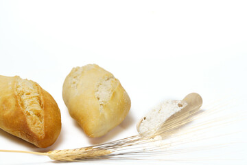 Loaves of bread with flour and ears of wheat isolated on white background and copy space