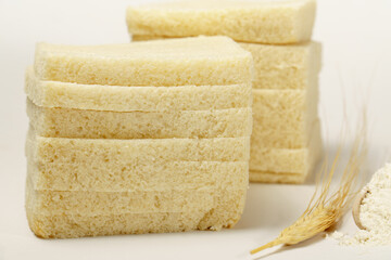 bread loaf with a wooden spoon with flour and ears of wheat isolated on white background and copy space