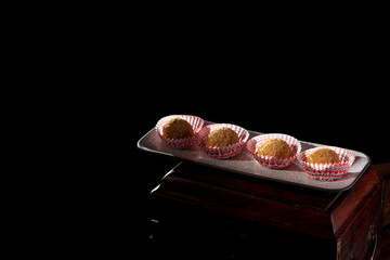 Chinese flour egg tarts, a delicious snack from Guizhou, China, with a dark background and close-up light