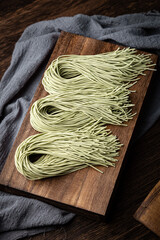 Traditional handmade noodles from Asian countries, ancient production techniques and culture, on a wooden cutting board indoors