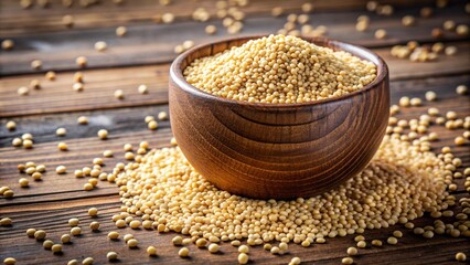 A wooden cup containing plump, golden quinoa grains, displayed on a textured wooden surface with some grains artfully spilled to highlight their spherical shape.