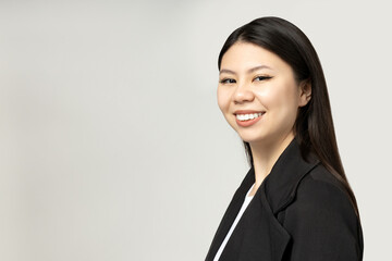 A girl of Asian appearance in a strict, classic suit.