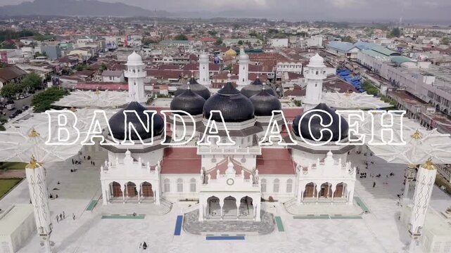 Landscape video with the text "Welcome to Banda Aceh" written in white on a beautiful aerial view of Baiturrahman Great Mosque in Banda Aceh, Aceh, Indonesia as video background