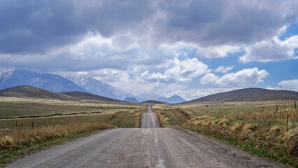 
We see a beautiful landscape, a road between mountains and meadows, with a stormy and very charged sky, in the background the Andes mountain range, Las Carreras Mendoza Arg road.