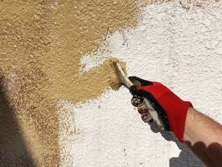 brush painting plaster, coating of an old wall by brown