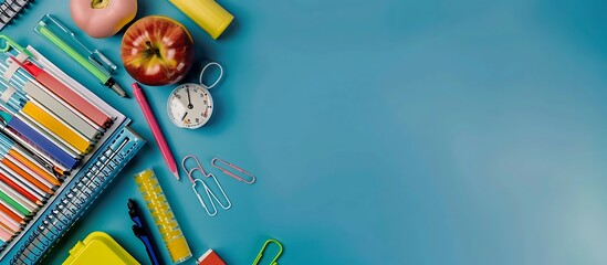 Aerial photo of assorted school supplies on a blue backdrop, clean sharp focus, soft shadows, space for copy.
