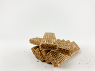chocolate wafer biscuits arranged in a creative formation on a white background. chocolate wafer biscuits on a white background. One biscuit is broken in half, showcasing its layered structure.