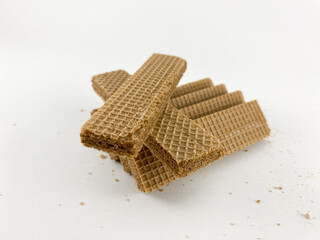 chocolate wafer biscuits arranged in a creative formation on a white background. chocolate wafer biscuits on a white background. One biscuit is broken in half, showcasing its layered structure.