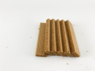crispy wafer sticks arranged in a staggered pattern on a white background. The wafer sticks have a light brown color and a delicate texture. Wafers with chocolate flavored cream on a white background
